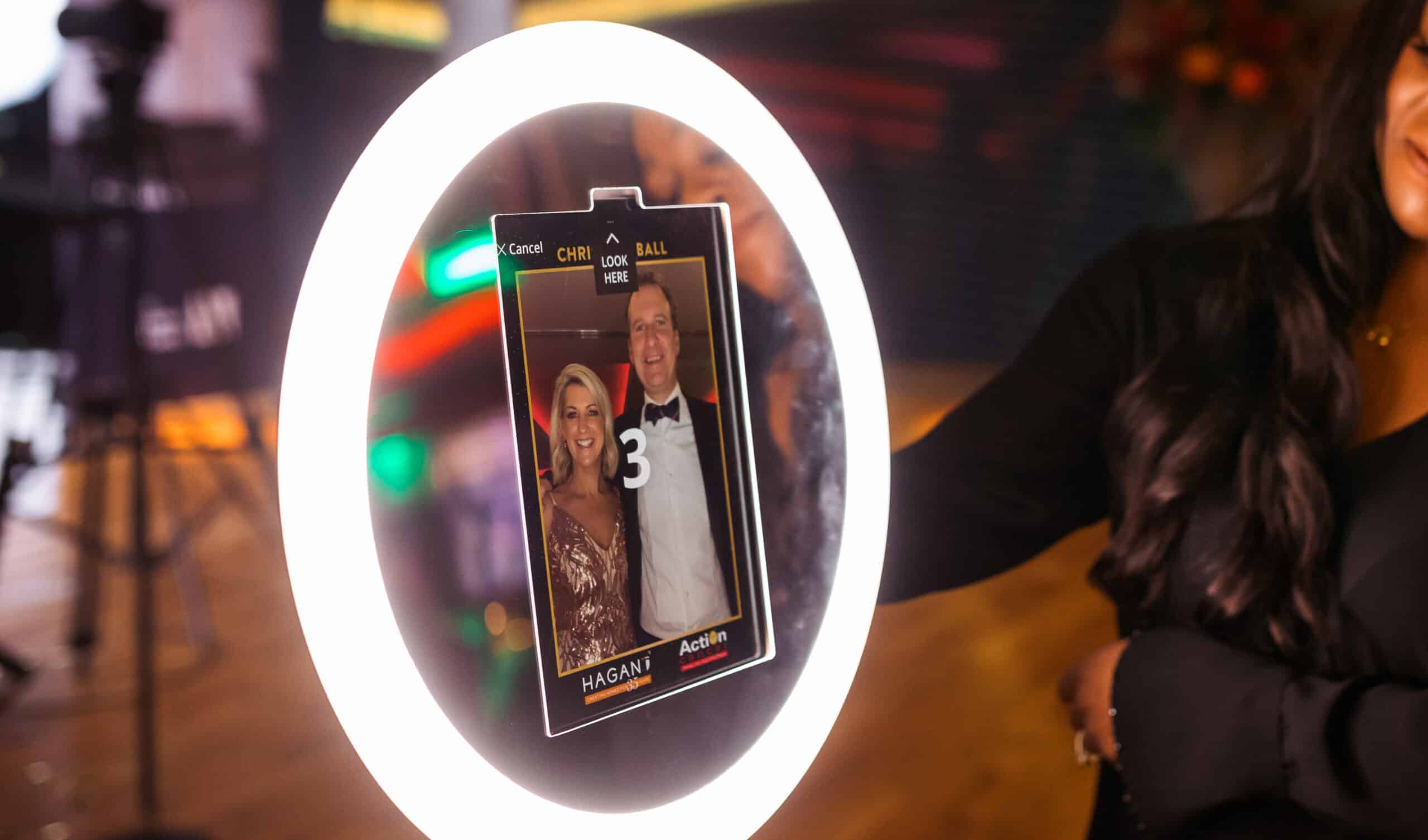 Ring light photo booth screen showing a couple in formal attire