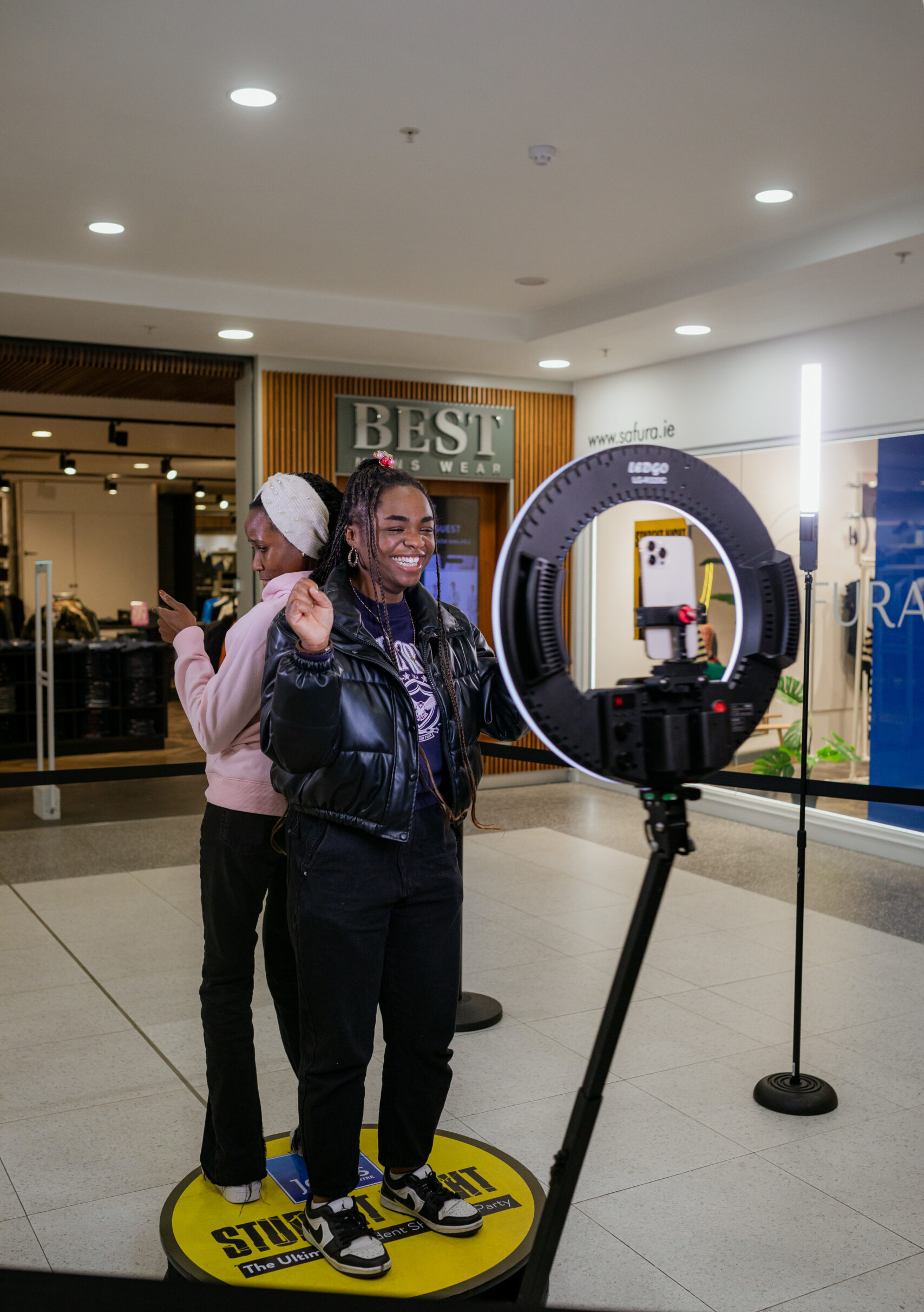 Woman posing at a ring light photo booth inside a shopping center
