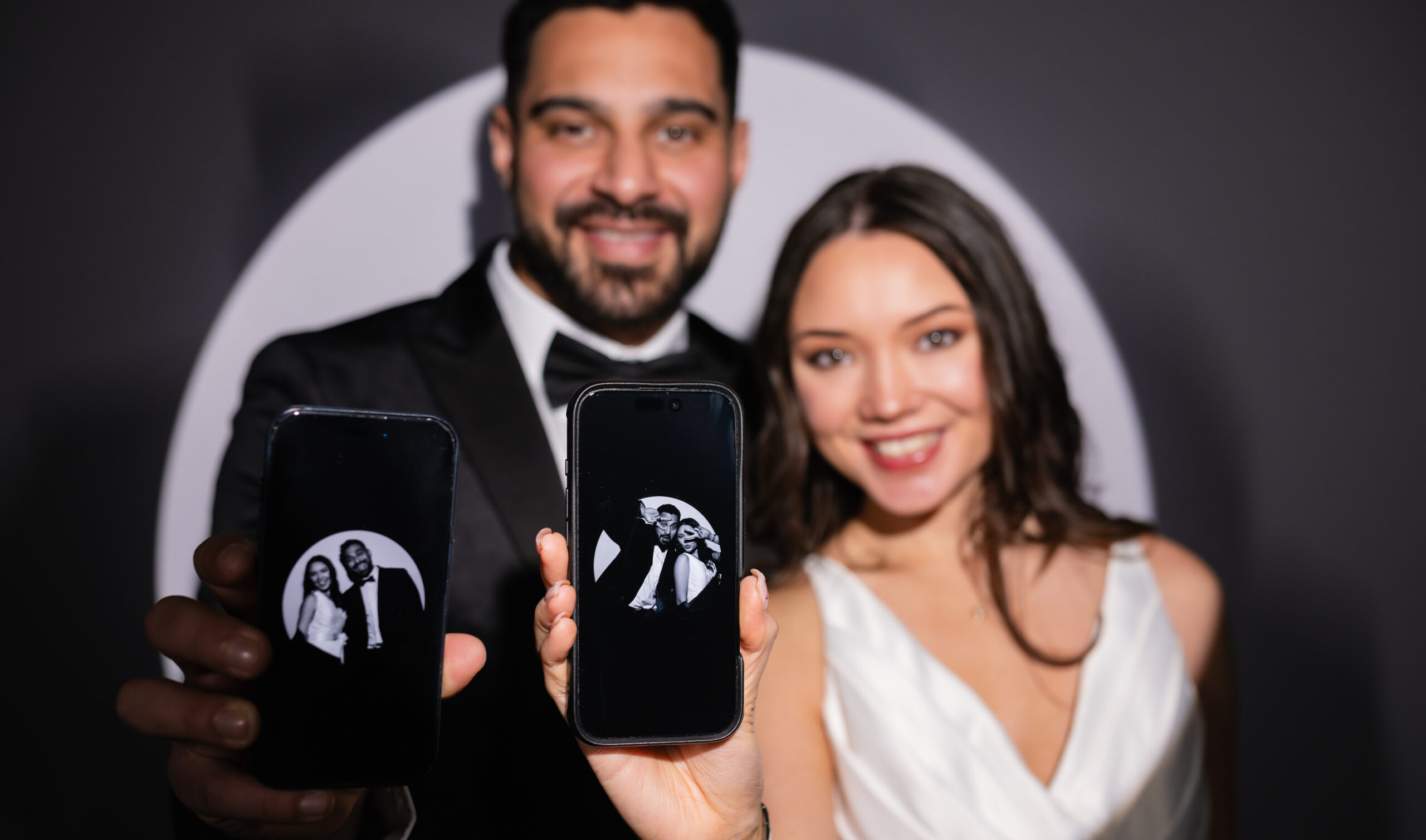 Couple in formal attire posing cheek to cheek in a photo booth portrait