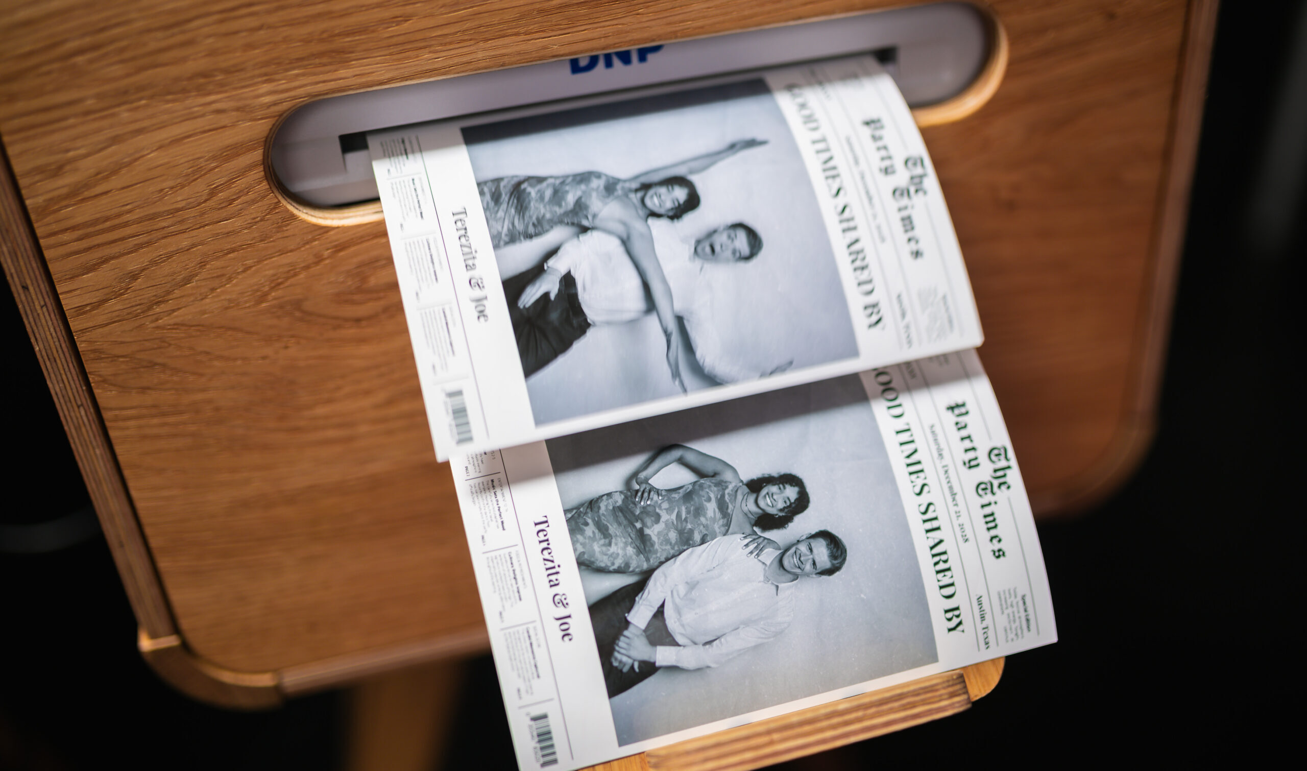 Photo booth printer producing black-and-white photo strips
