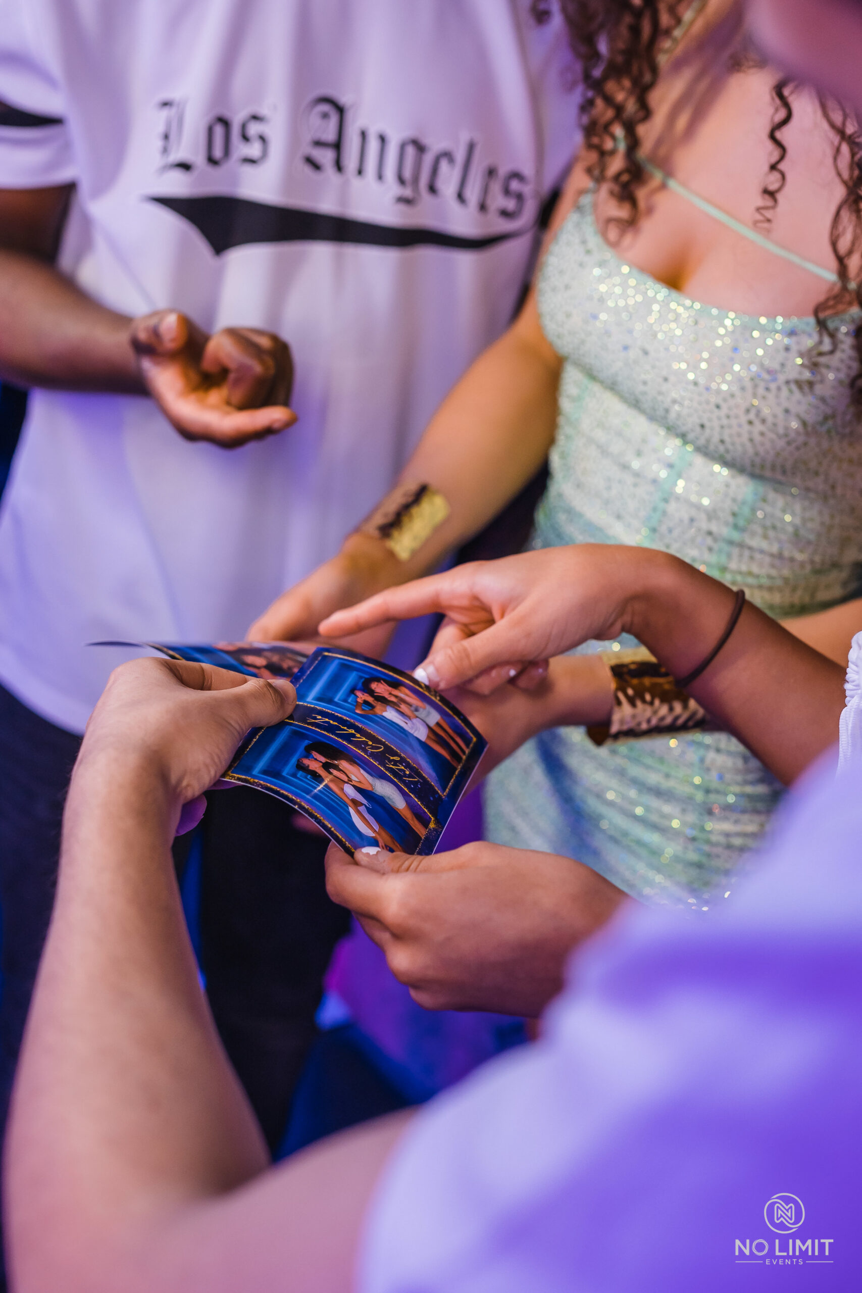 Young people at a party, looking at copies of prints they had taken