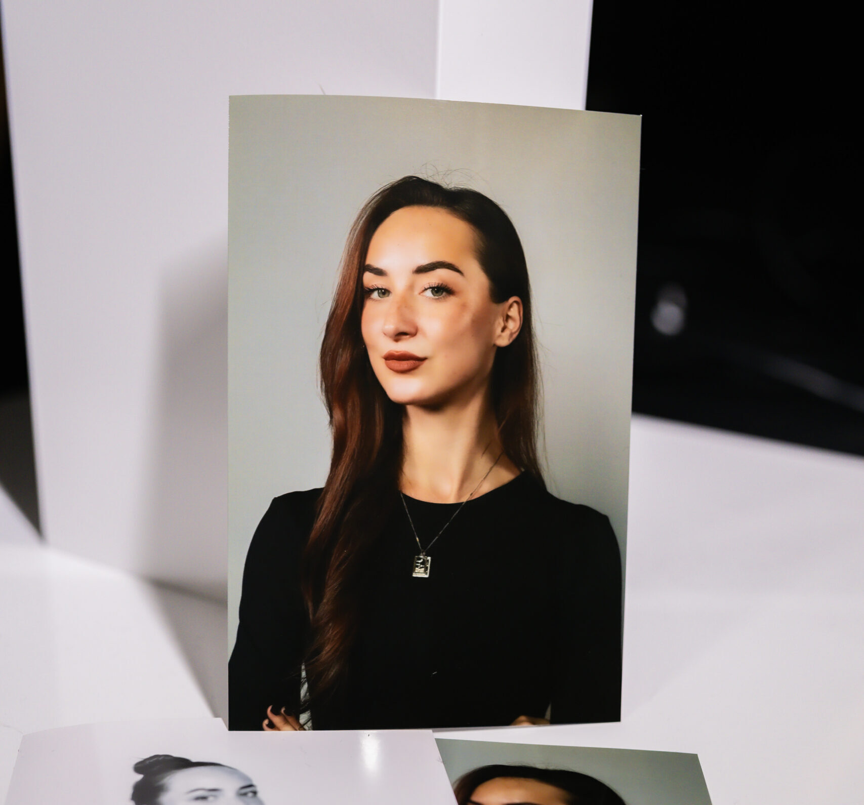 Woman in a black top posing against a white photo booth backdrop