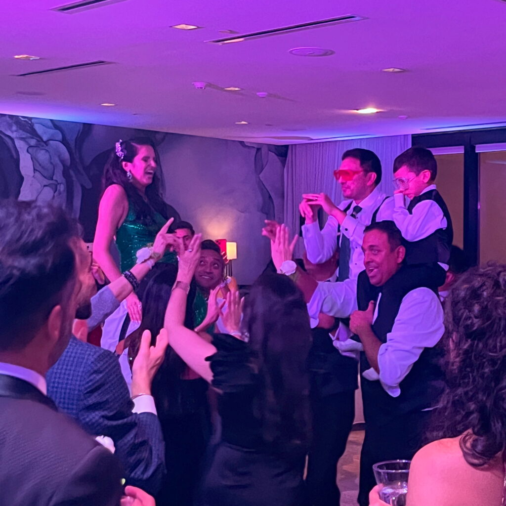 Guests dancing under purple party lighting at a DJ event