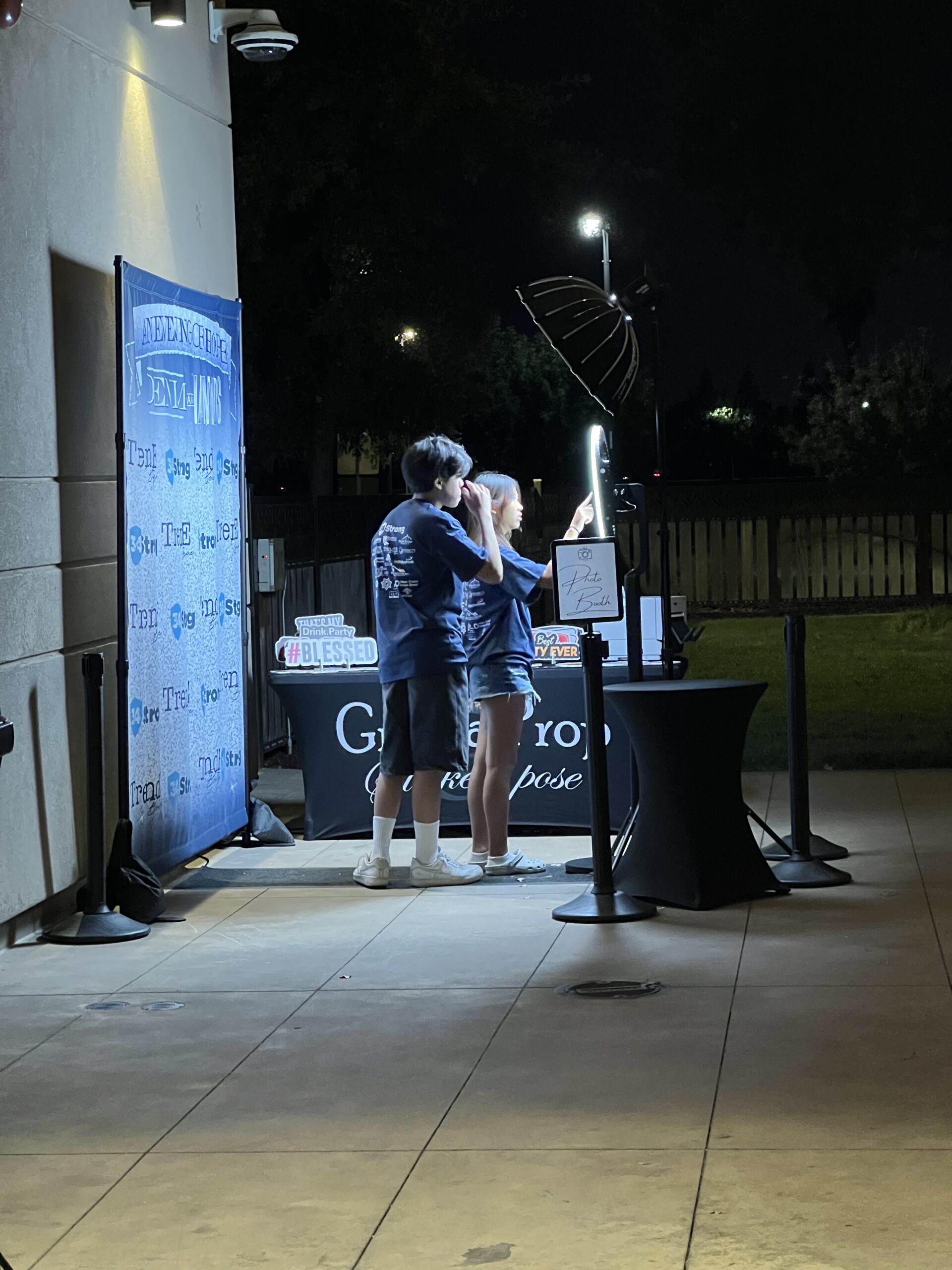 Guests at an outdoor photo booth setup during a nighttime event
