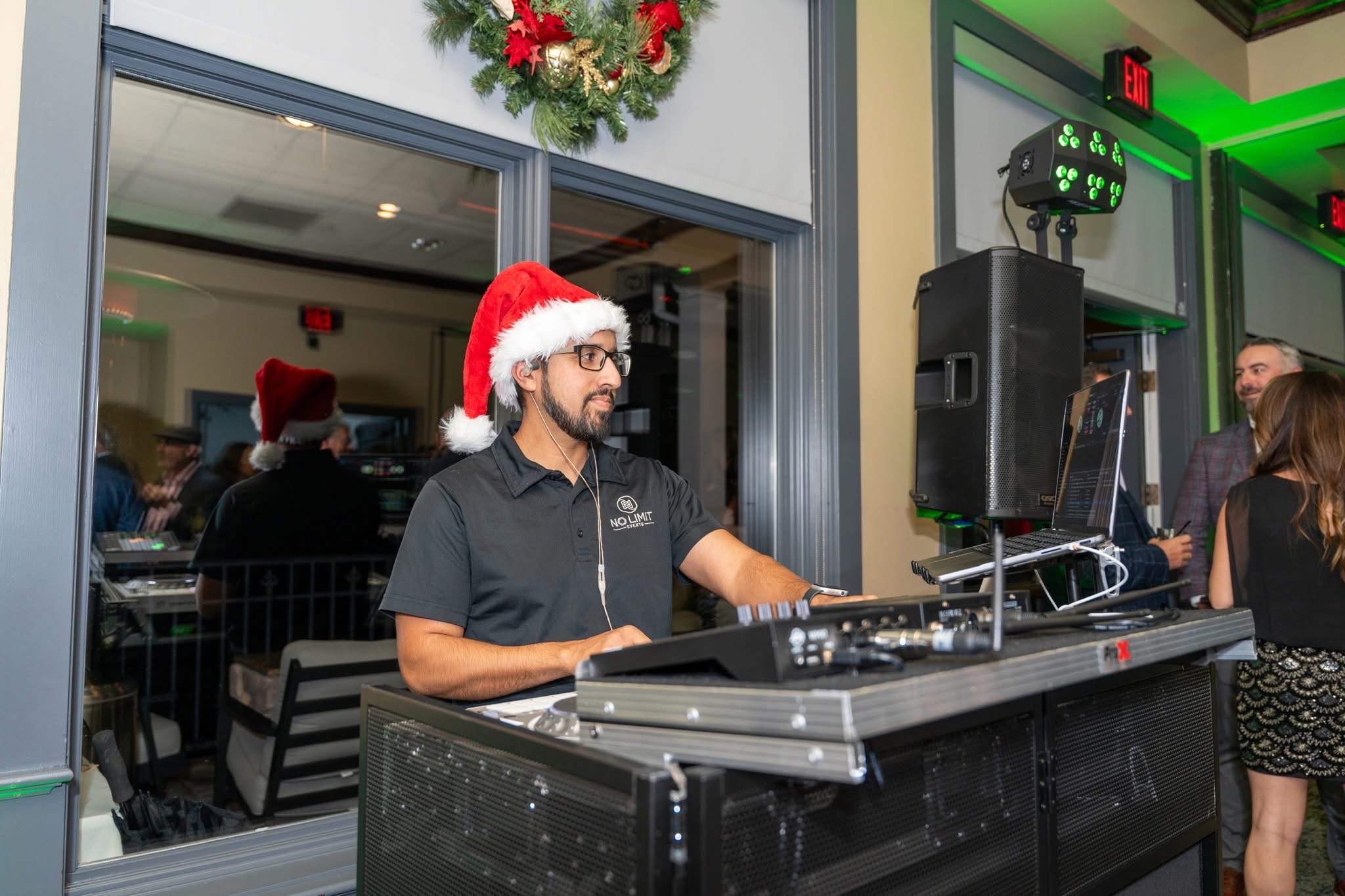DJ in a Santa hat playing music at a holiday party