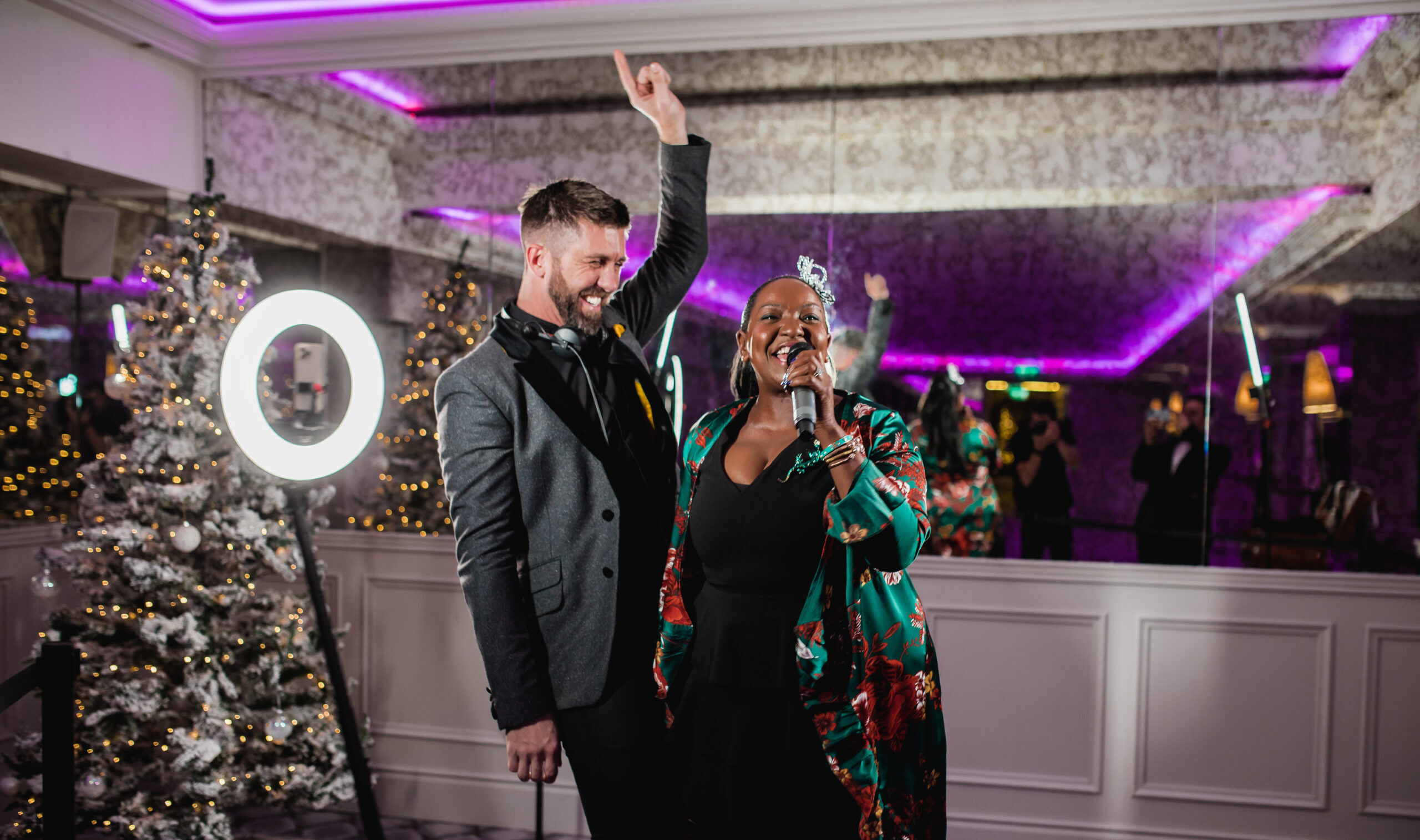 Man and woman dancing at a photo booth under purple lighting